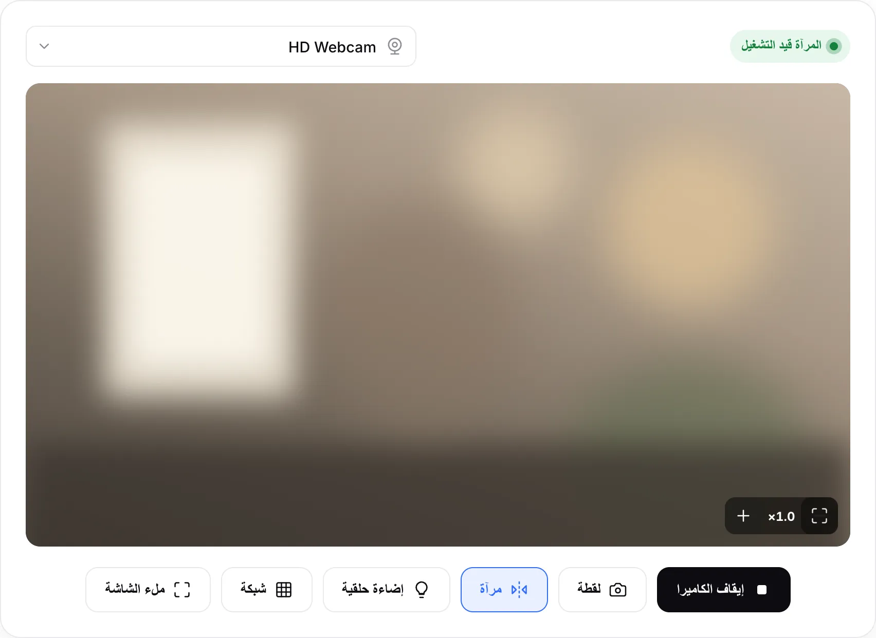 مرآة كاميرا الويب قيد التشغيل، مع الحالة «المرآة قيد التشغيل» وأزرار التكبير على الصورة وزر الإضاءة الحلقية