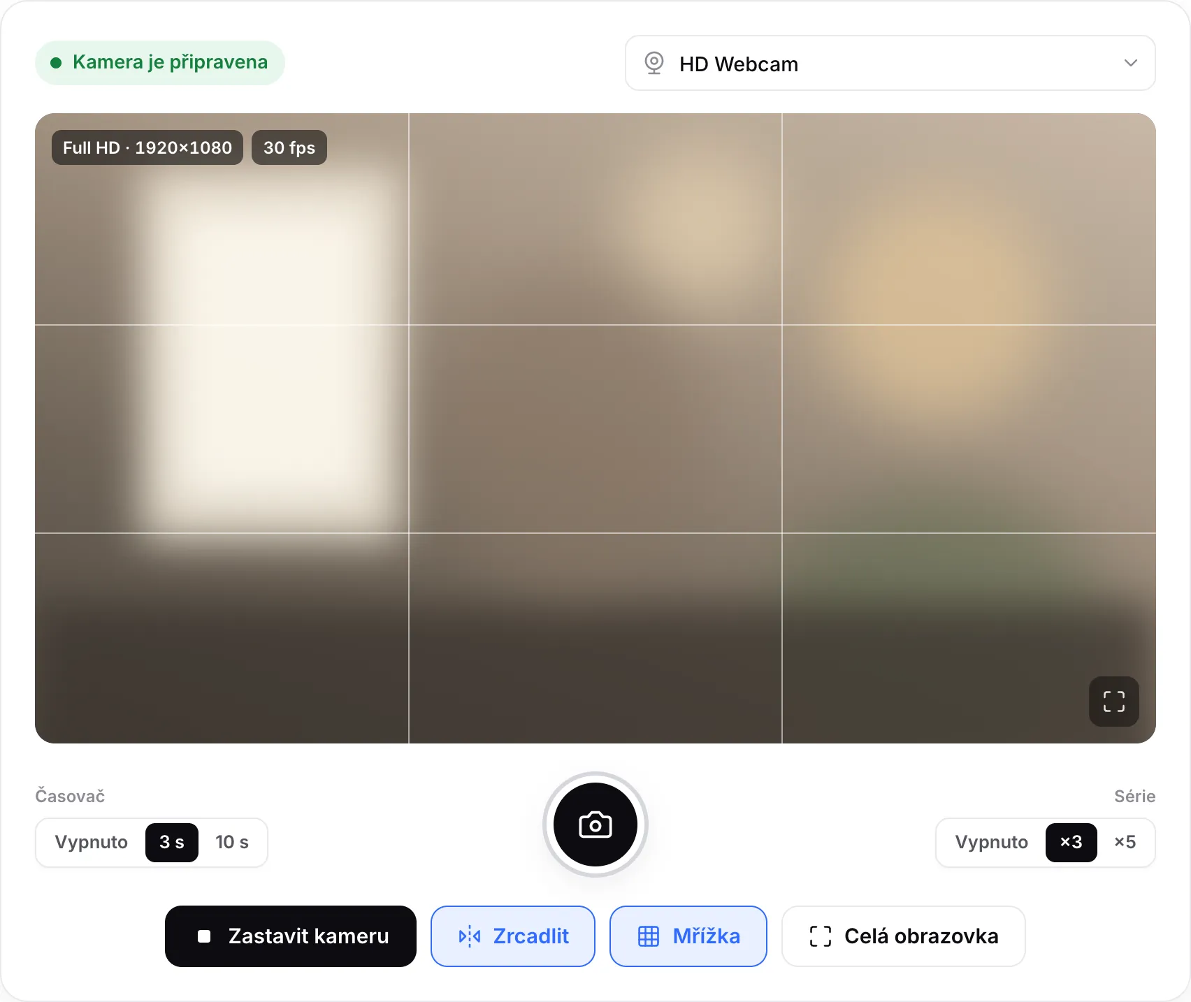 Online kamera se zapnutou mřížkou, časovačem 3 s a sérií ×3 po obou stranách kulatého tlačítka spouště